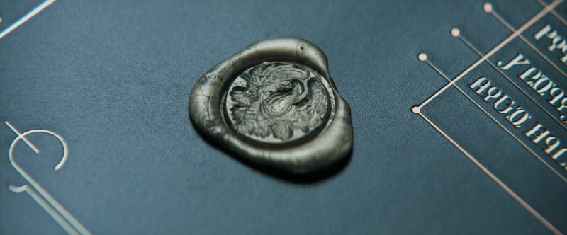 Still shot from Dune (2021). Close up shot of the Atreides seal. Seal design consisting of a detailed feathered hawk.