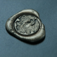 Still shot from Dune (2021). Close up shot of the Atreides seal. Seal design consisting of a detailed feathered hawk.